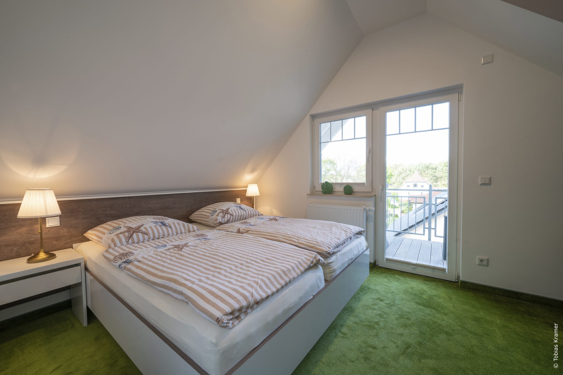 Schlafzimmer mit Doppelbett und eigenem Balkon
